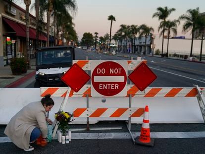 Stephanie Kozofsky, 31, leaves flowers and candles to honor the victims killed in Saturday's ballroom dance studio shooting in Monterey Park, Calif., Sunday, Jan. 22, 2023.