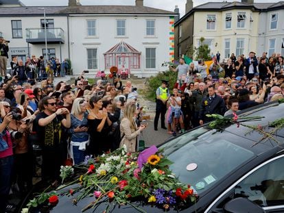 A hearse carrying the coffin of late Irish singer Sinead O'Connor passes outside her former home during her funeral procession as fans line the street to say their last goodbye to her, in Bray, Ireland, August 8, 2023.