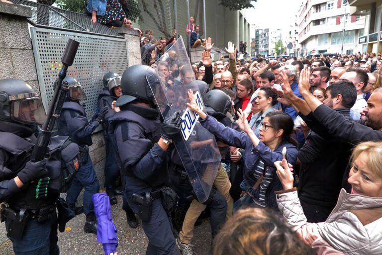 Voters at a school in Girona clash with riot police who were trying to seize ballot boxes.