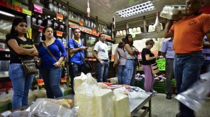 Customers line up to pay for food at a checkout in a Caracas supermarket.