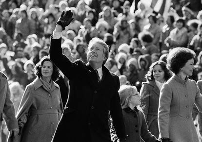 U.S. President Jimmy Carter waves to the crowd while walking with his wife, Rosalynn, and their daughter, Amy, along Pennsylvania Avenue. The Carters elected to walk the parade route from the Capitol to the White House following his inauguration in Washington, Jan. 20, 1977.
