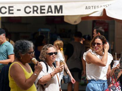 Tourists eat ice cream on the street in Málaga.