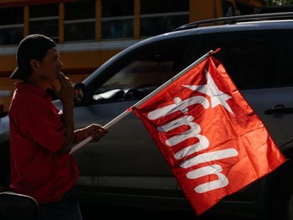 A supporter carries an FMLN flag during a campaign closing rally in San Salvador, January 27, 2024.