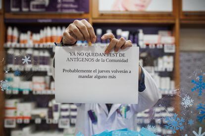 A pharmacist puts up a sign warning customers that they have sold out of antigen tests.