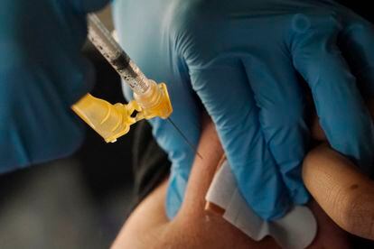 A nurse administers a Moderna COVID-19 booster vaccine at an inoculation station next to Jackson State University in Jackson, Miss., Friday, Nov. 18, 2022