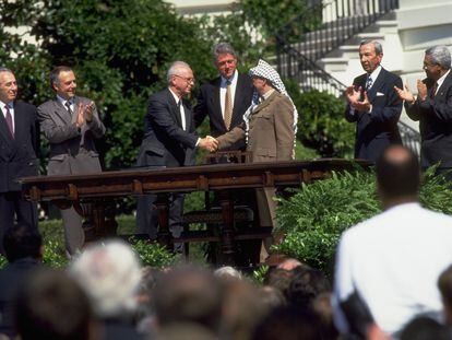Yitzhak Rabin and Yasser Arafat shake hands after signing the Oslo Accords at the White House in 1993.