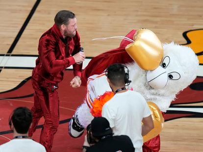 Former MMA fighter Conor McGregor punches Burnie, the Miami Heat mascot, during a break in Game 4 of the basketball NBA Finals against the Denver Nuggets, Friday, June 9, 2023, in Miami.