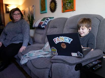 Jessica Blalack, left, watches as her son Phoenix Blalack, 6, works with a tutor on his laptop in his Indianapolis home, on March 7, 2023.
