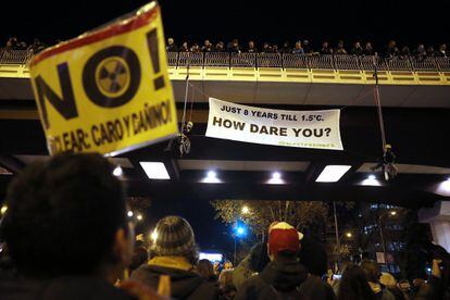 Two people hold a banner from the Eduardo Dato bridge in Madrid.