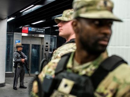 New York State Police officer and members of the New York State National Guard stand guard inside the entrance of subway station in New York City, U.S., March 7, 2024.