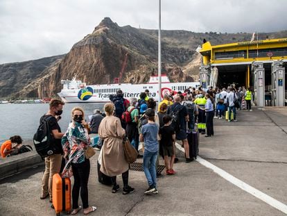 Passengers line up for a ferry after eruption forces La Palma airport to close.