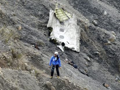 A member of the recovery team pictured on the crash site, next to a large piece of the plane&rsquo;s fuselage.