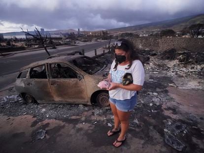 Summer Gerlingpicks up her piggy bank found in the rubble of her home following the wildfire Thursday, Aug. 10, 2023