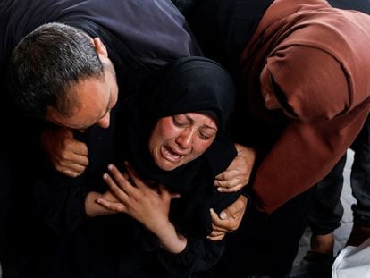 A woman cries next to Palestinians killed by an Israeli bombing in Rafah on Tuesday.
