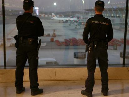 Two police officers patrol Madrid-Barajas airport after the Paris attacks.