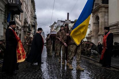 Soldier carry the coffin of soldier Yurii Bulharu during a funeral ceremony outside the Holy Apostles Peter and Paul Church in Lviv, western Ukraine, on Saturday, Feb. 25, 2023.