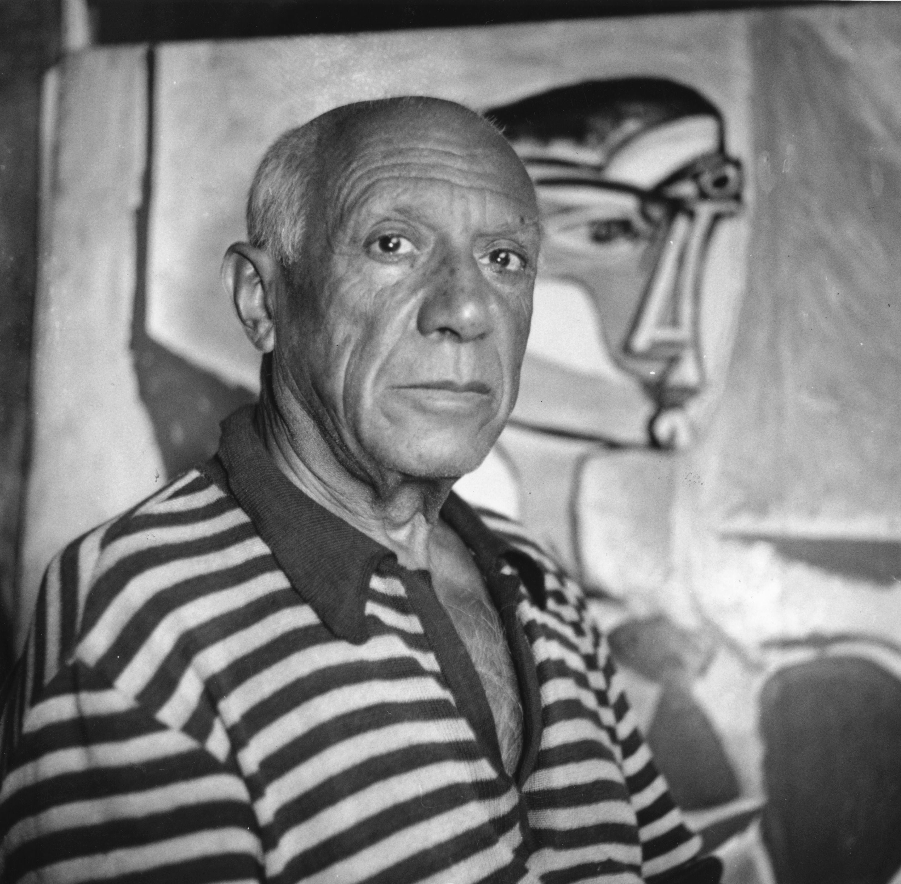 Picasso, in front of one of his paintings in his Cannes home.