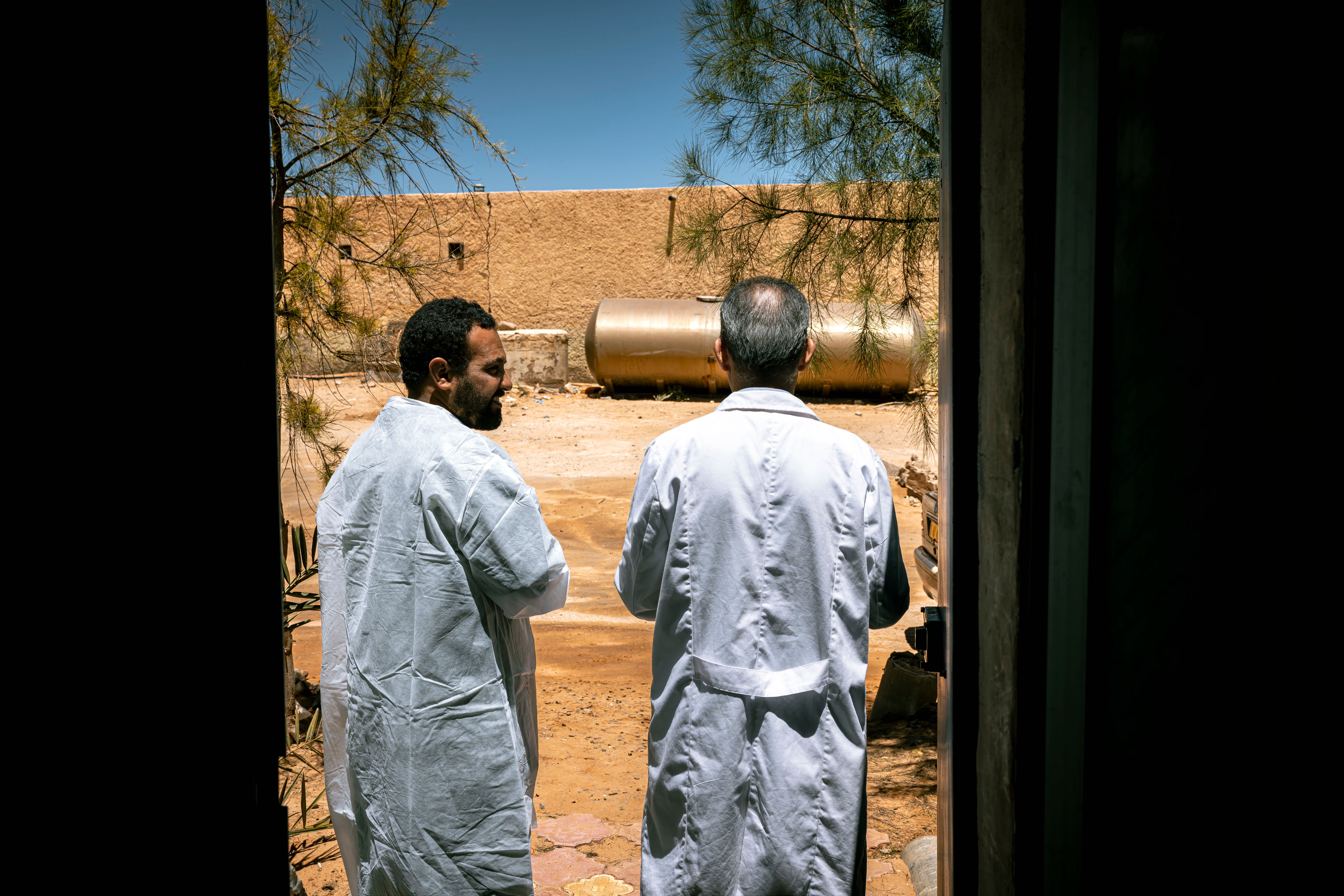 Brahim Saleh Labeid and Mohamed Lamin Abdi talk at the laboratory door on April 29.