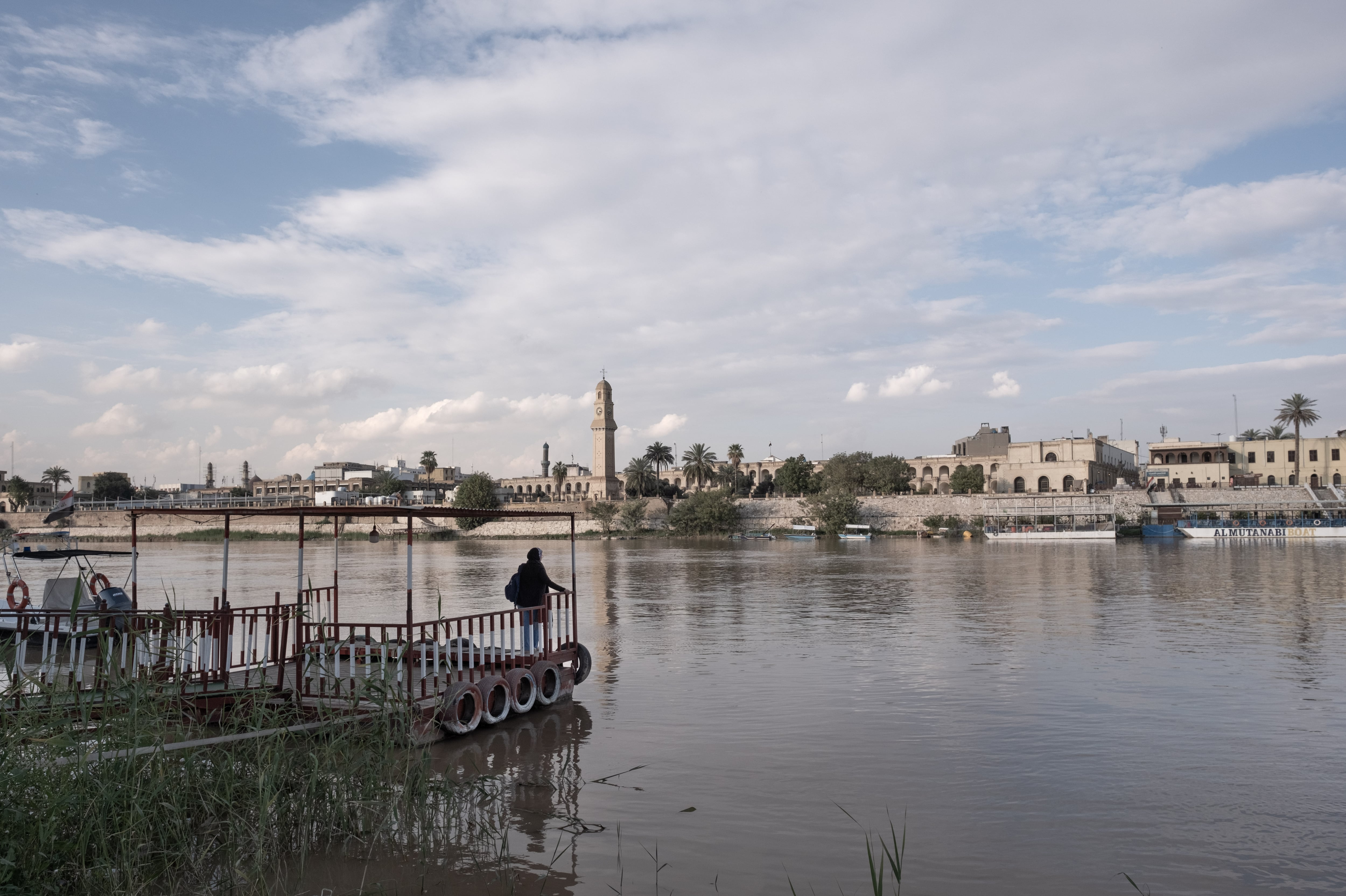 A customer waits for a water taxi to cross the River Tigris in Baghdad on March 25.