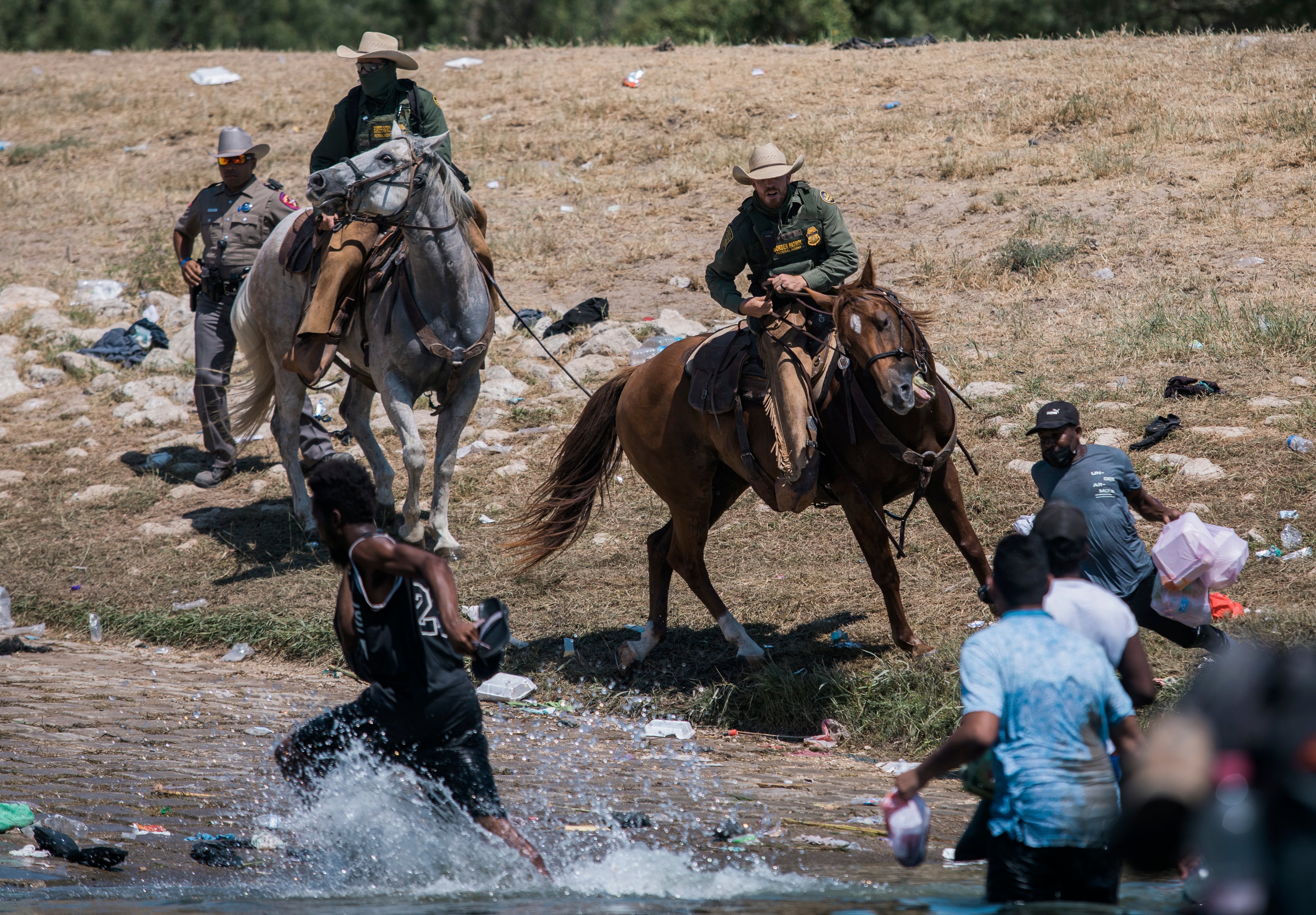 U.S. Customs and Border Protection agents attempt to contain migrants as they cross the Rio Grande from Ciudad Acuña, Mexico, to Del Rio, Texas, on September 19, 2021.