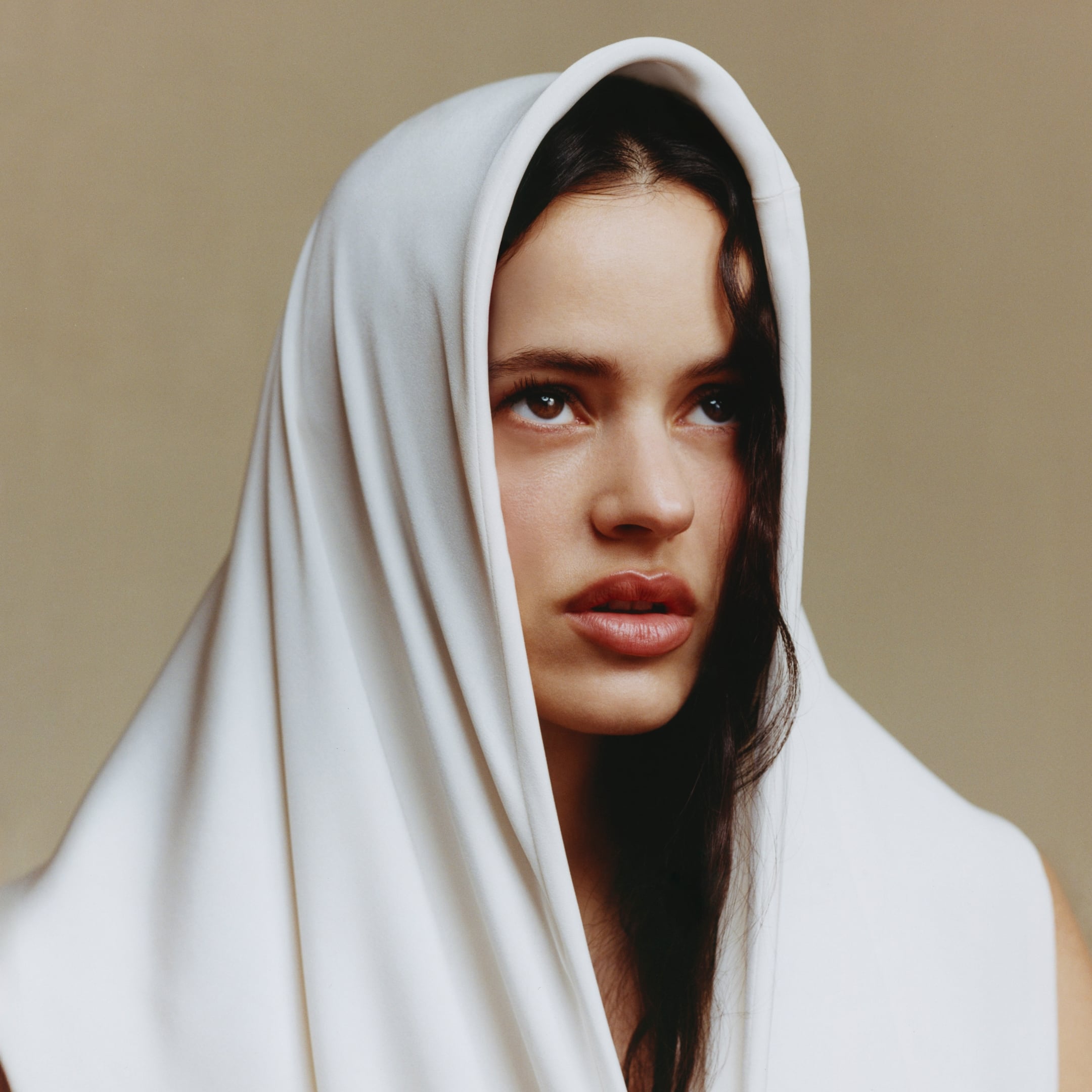 Rosalía wearing a white dress with a hood by Max Mara.