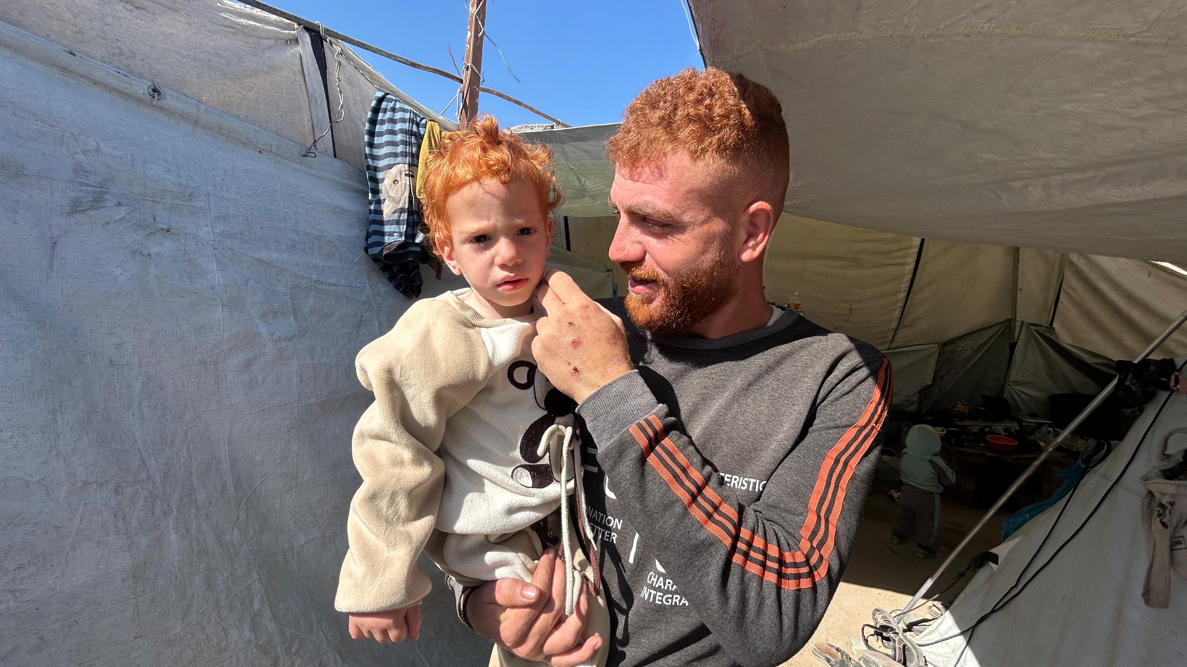 Ibrahim Badr with his father in a displaced persons camp in Gaza City in April.
