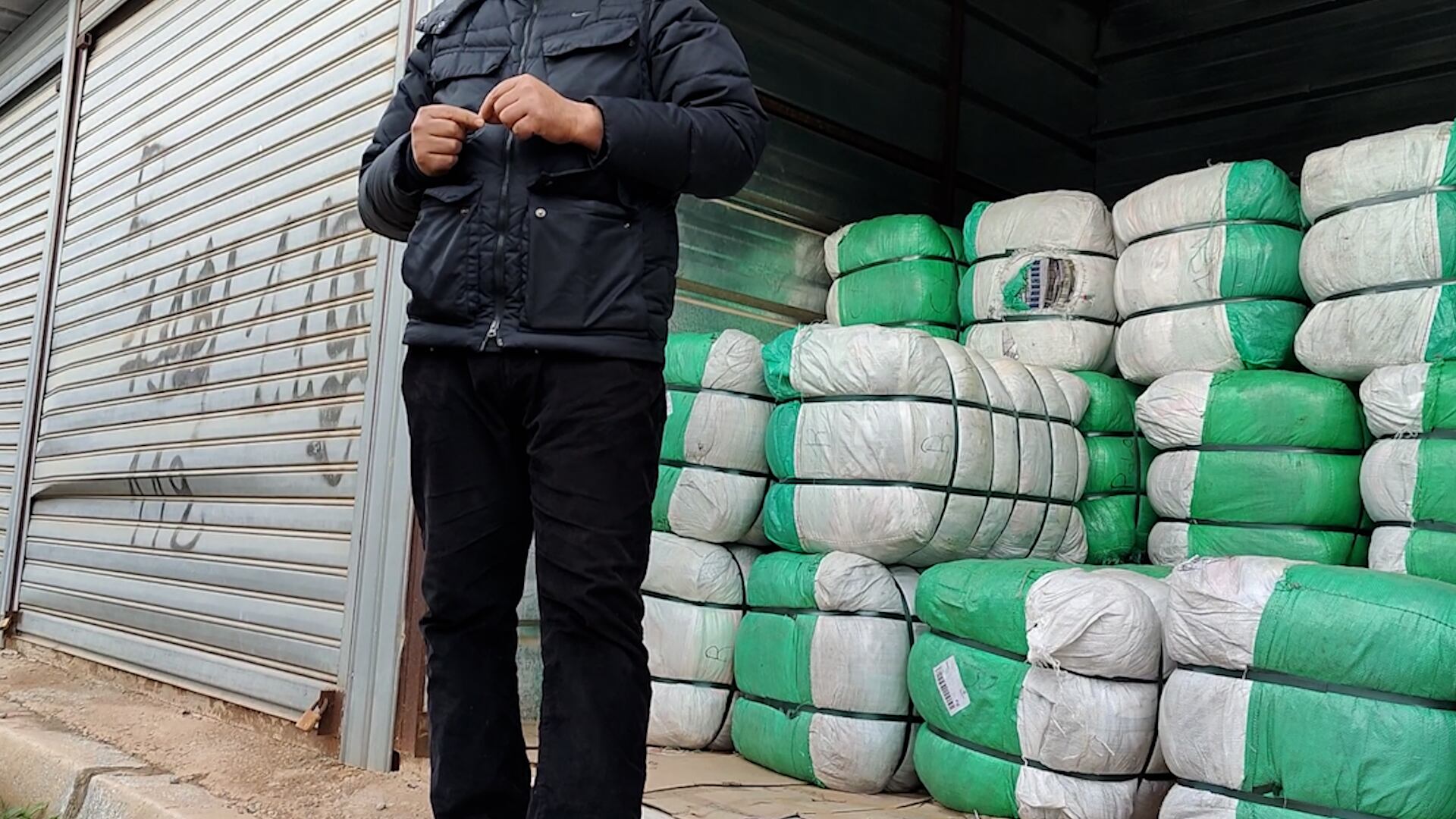 Faruq (not his real name), a former smuggler who once trafficked clothes between Nador and Melilla, poses in front of one of the warehouses in which he stores bales of clothes that were bought without an invoice.