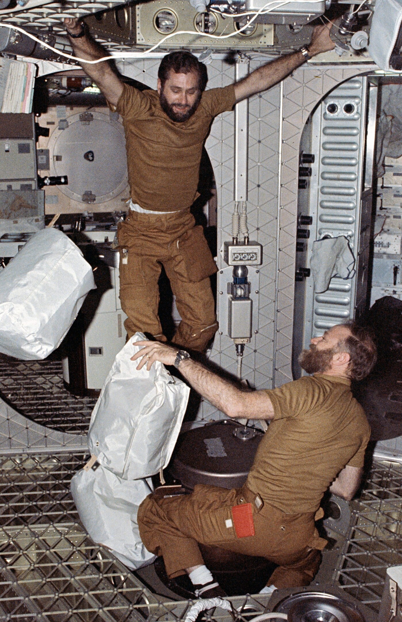 Astronauts William Pogue (left) and Gerald Carr dispose of garbage bags down the chute.