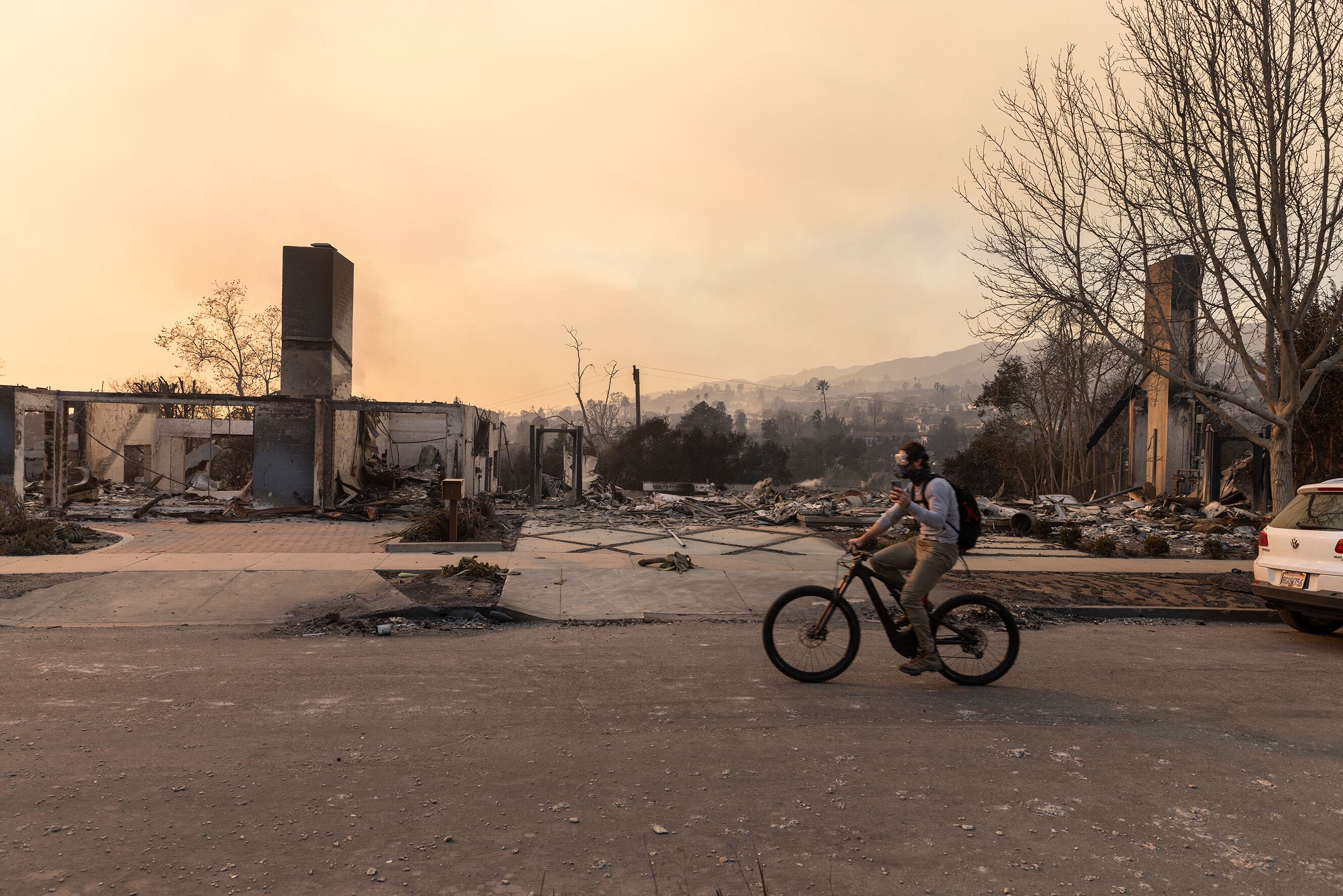 A cyclist rides through Pacific Palisades, one of the fire-ravaged areas of the Los Angeles wildfires, California, on January 9, 2025.