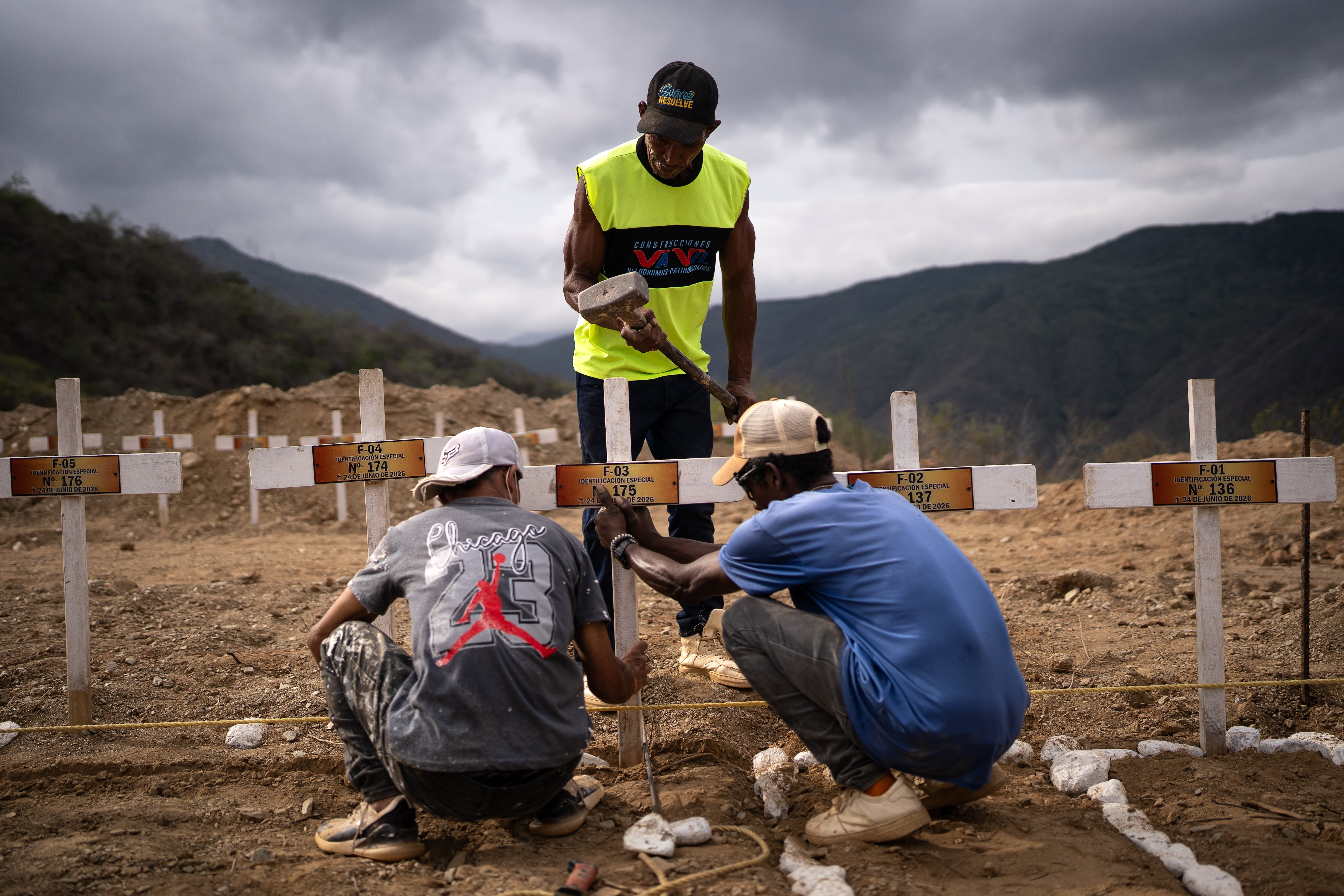 A group of workers install crosses on the graves of unidentified bodies at La Esperanza cemetery in La Guaira, July 6.