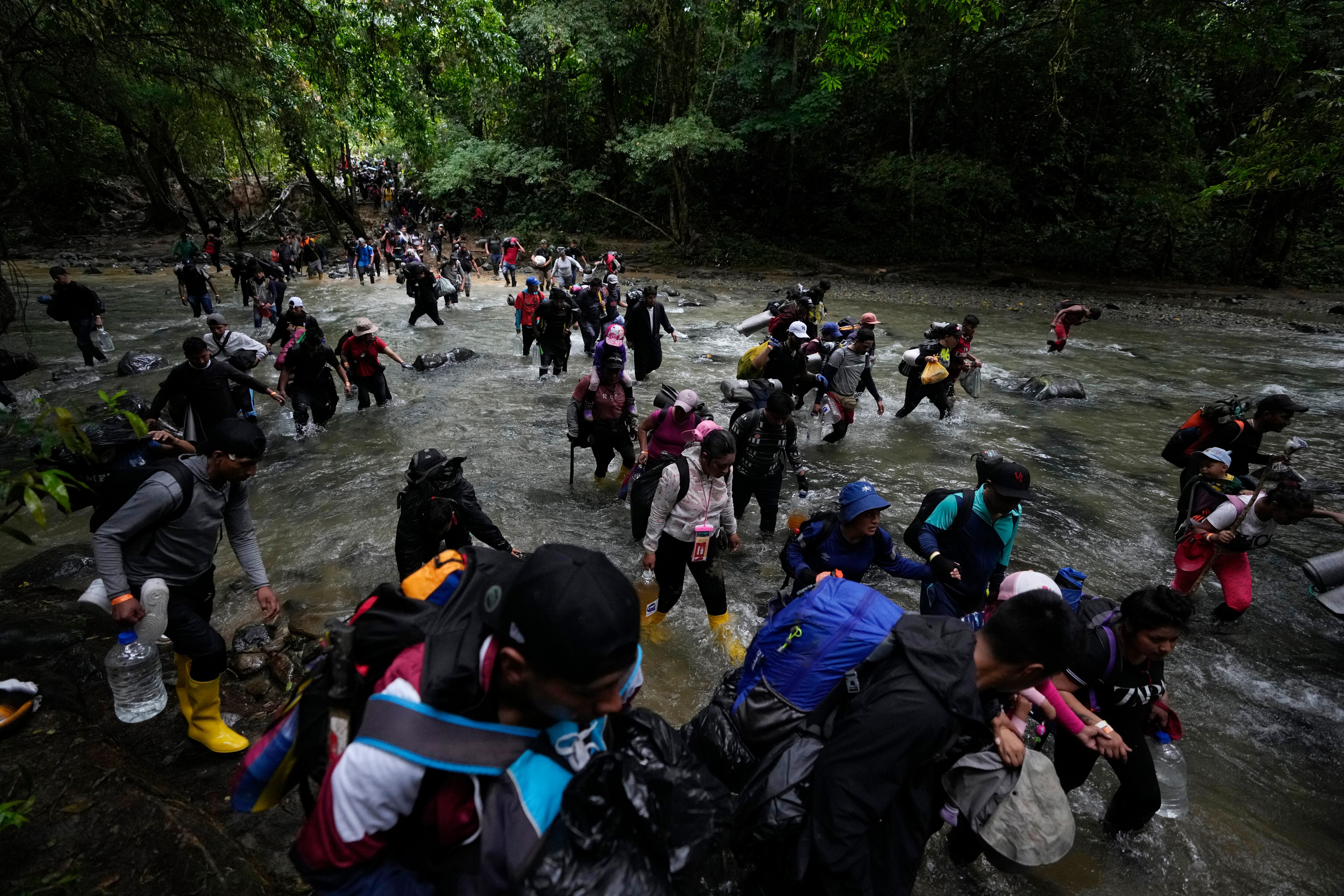 Migrants cross a river in the Darién rainforest, October 2022.