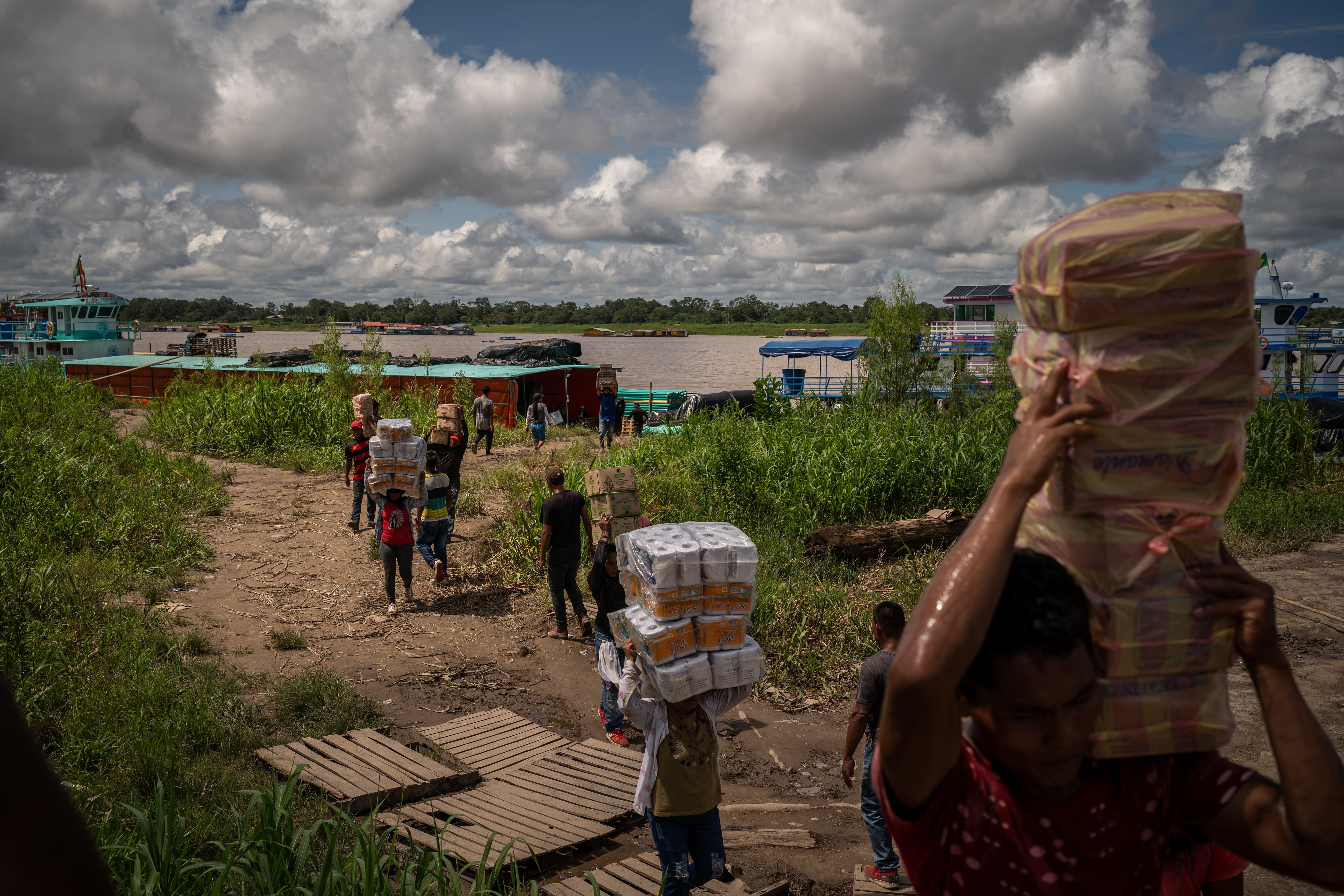 Traders unload merchandise at the port of Leticia, in the Amazonas (Colombia) on December 11, 2024.