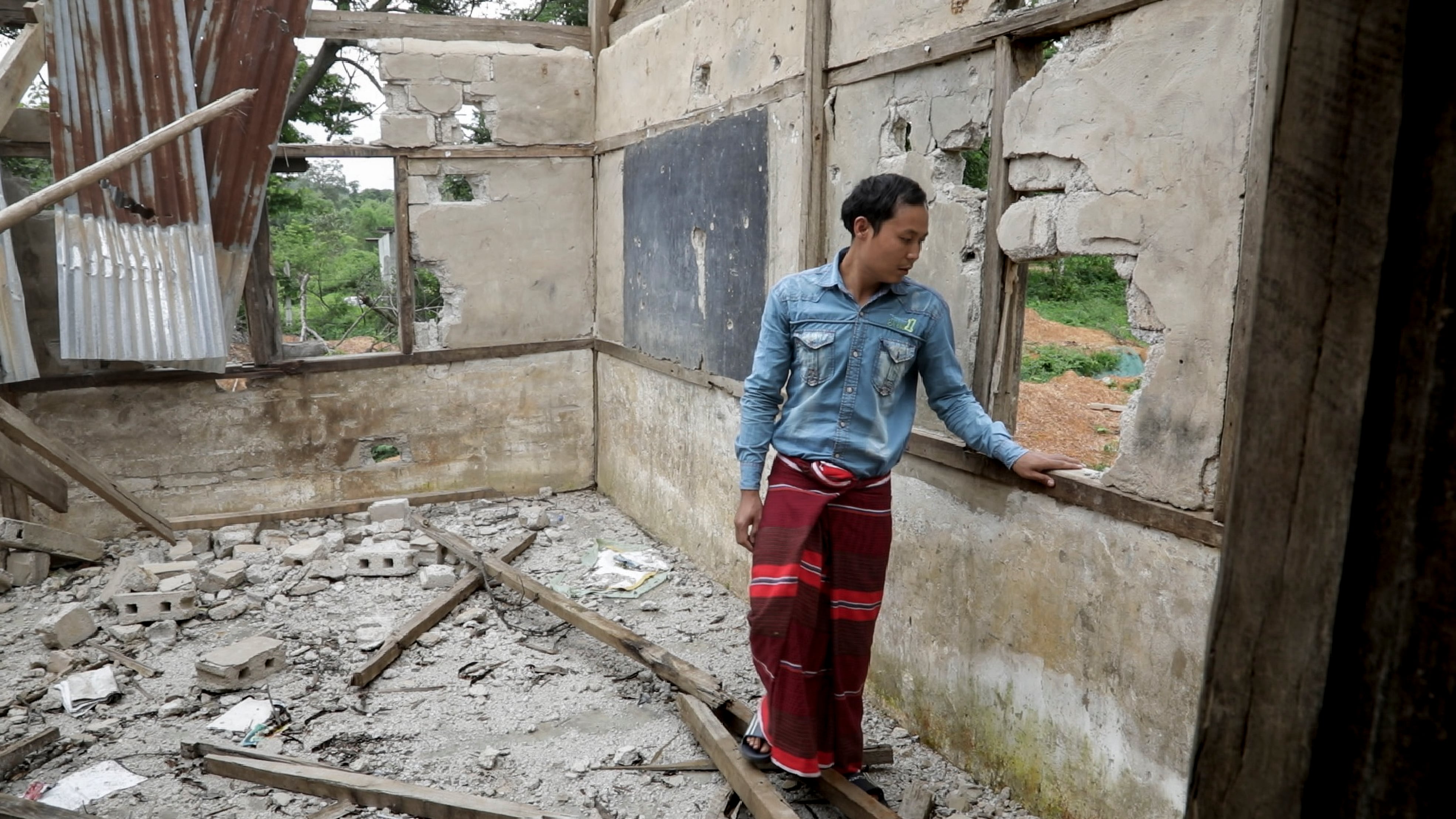 Nay Lin Aung, 26, is a Myanmar mathematics teacher. In the image, he visits the ruins of the Demoso school in which he taught until it was bombed in February. Four students died in the attack.