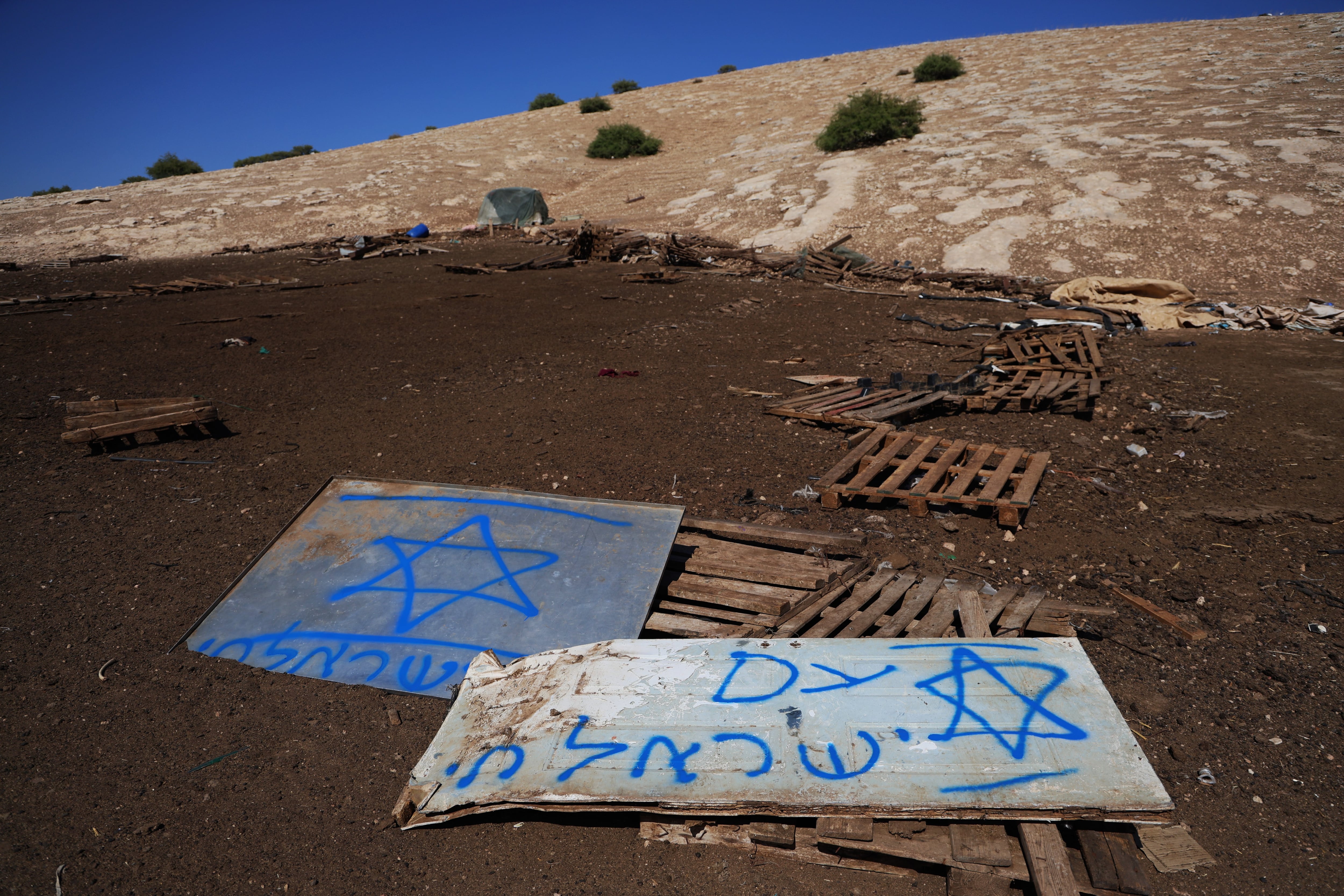 Graffiti reading “The nation of Israel lives” on the remains of a Bedouin community expelled from the occupied West Bank a few hours earlier, in a July 3 image.