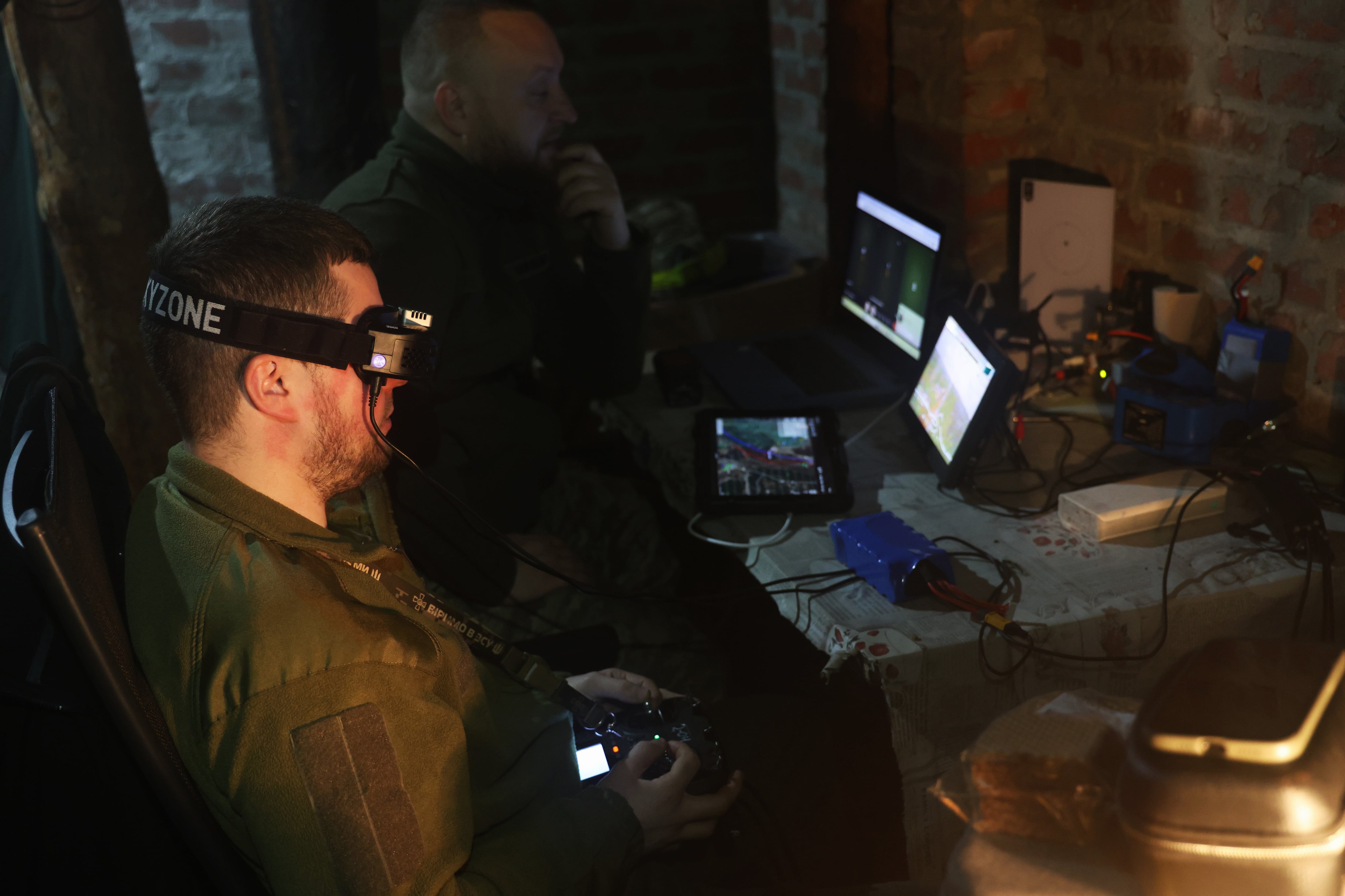 Red (with goggles), an Achilles unit pilot, controls the flight of a kamikaze drone over Russian positions on the Kharkiv front on May 13.