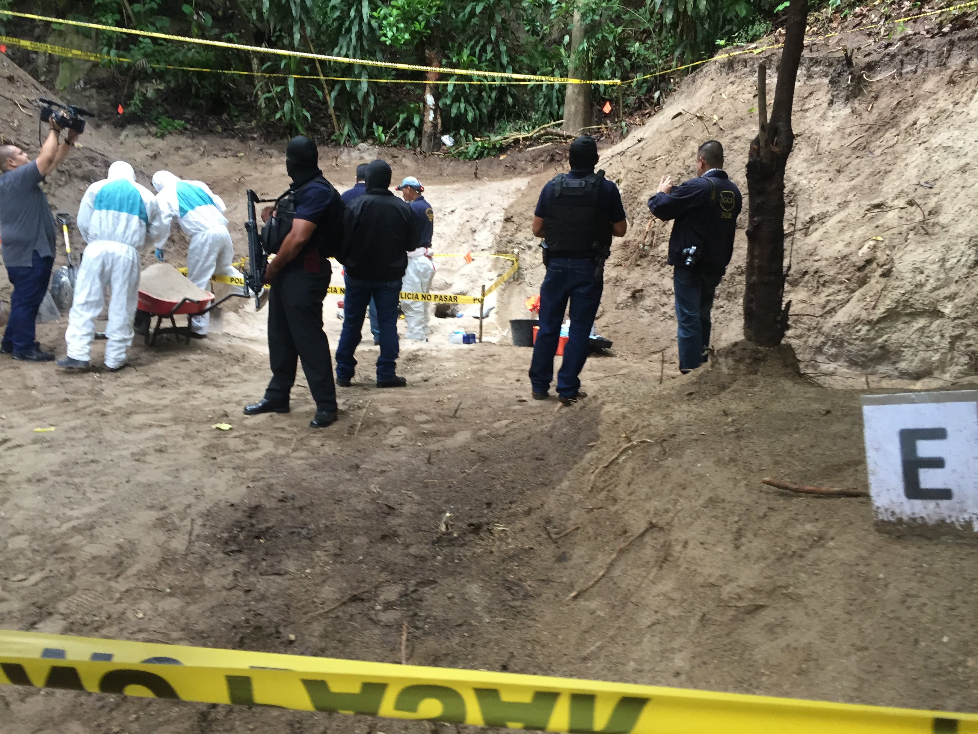 Federal agents guard a clandestine grave in the Vista al Lago development, in El Salvador.