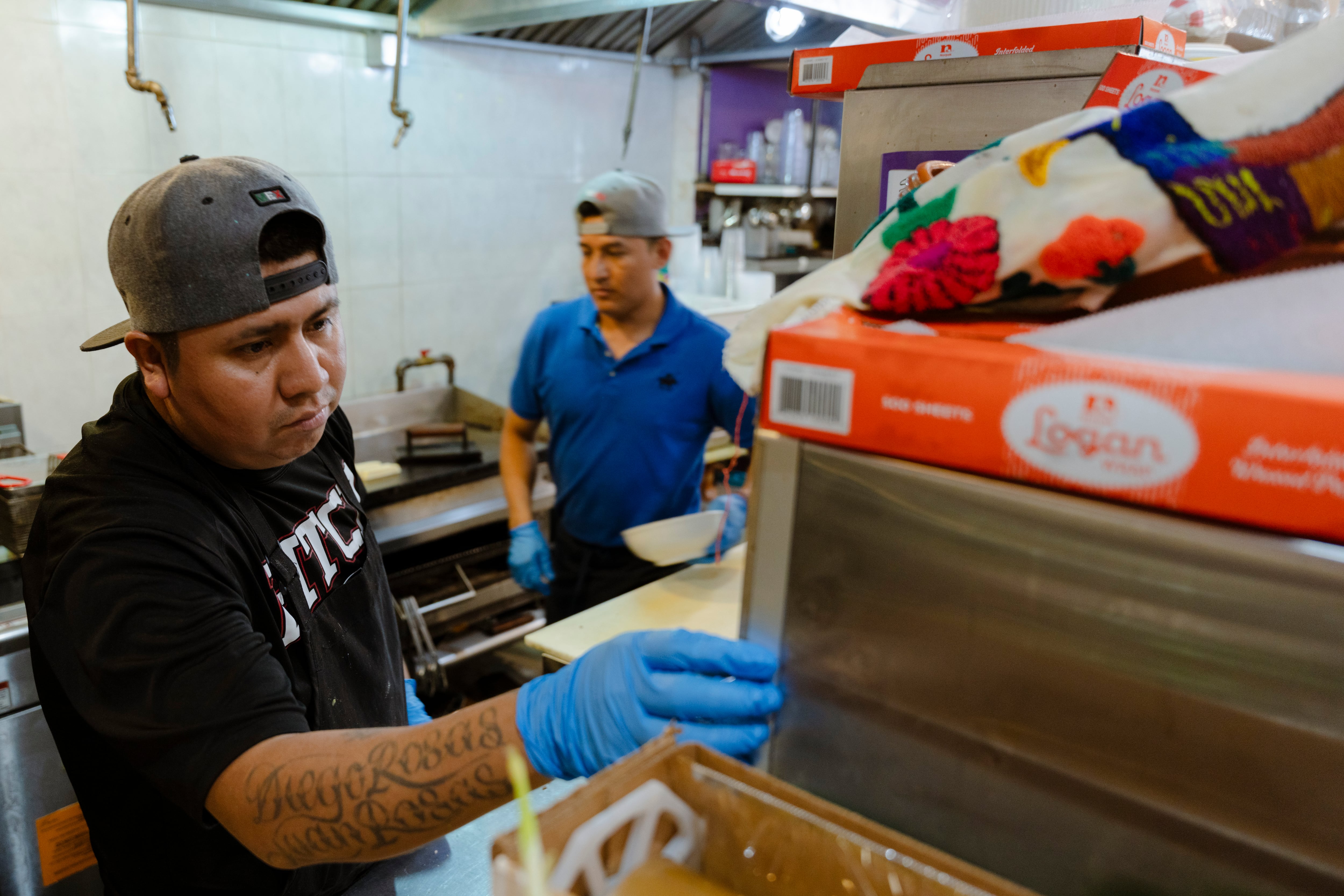 Catarino Rosas prepares food for a group of customers at La Morada restaurant in the borough of the Bronx, in New York City.