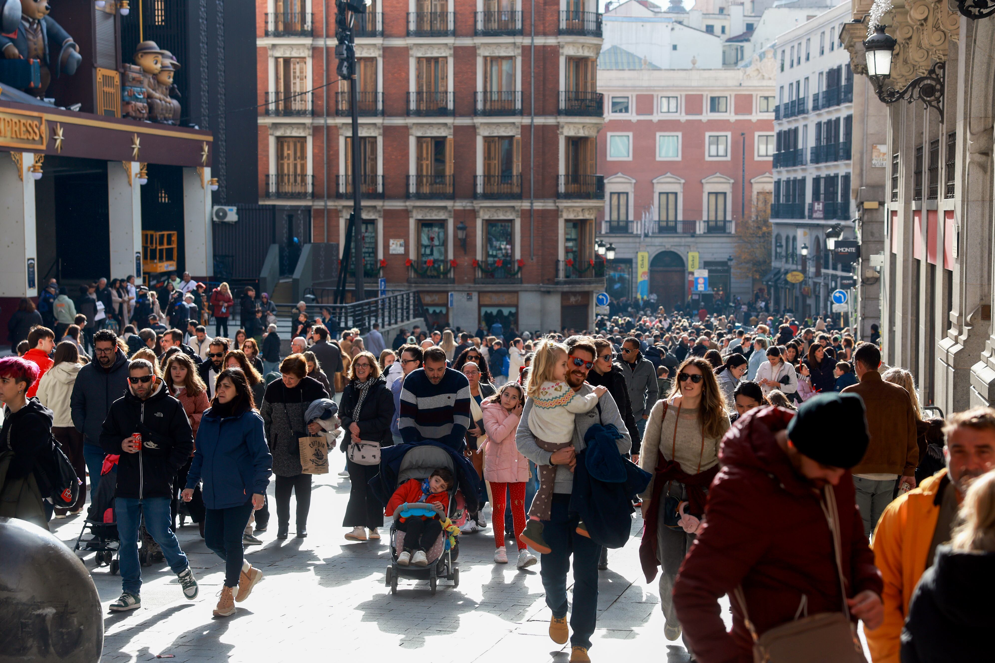 A multitude of people stroll along Preciados Street, in the center of Madrid.