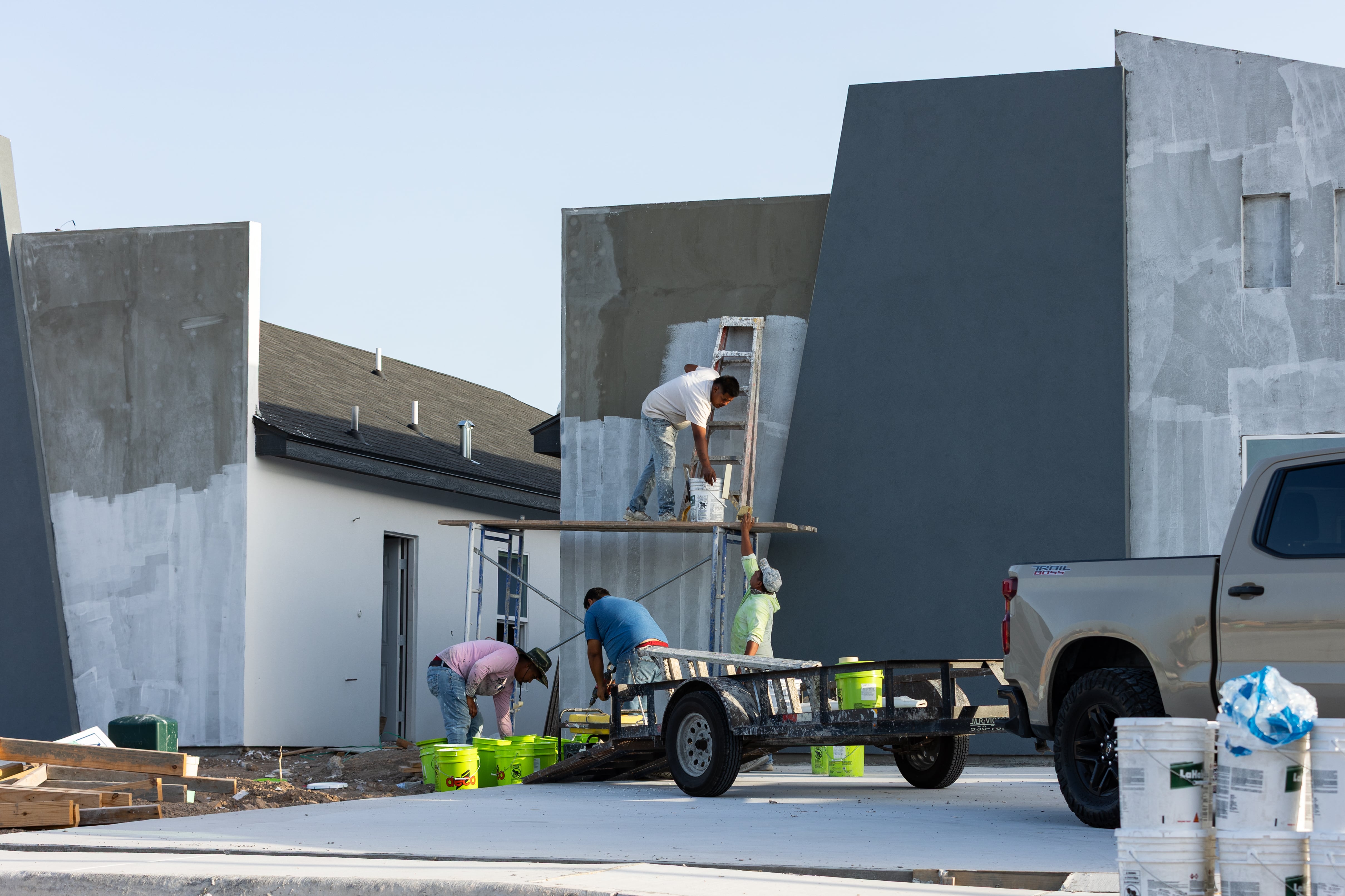 A construction crew works on the exterior of a house in Pharr, Texas, on September 15.
