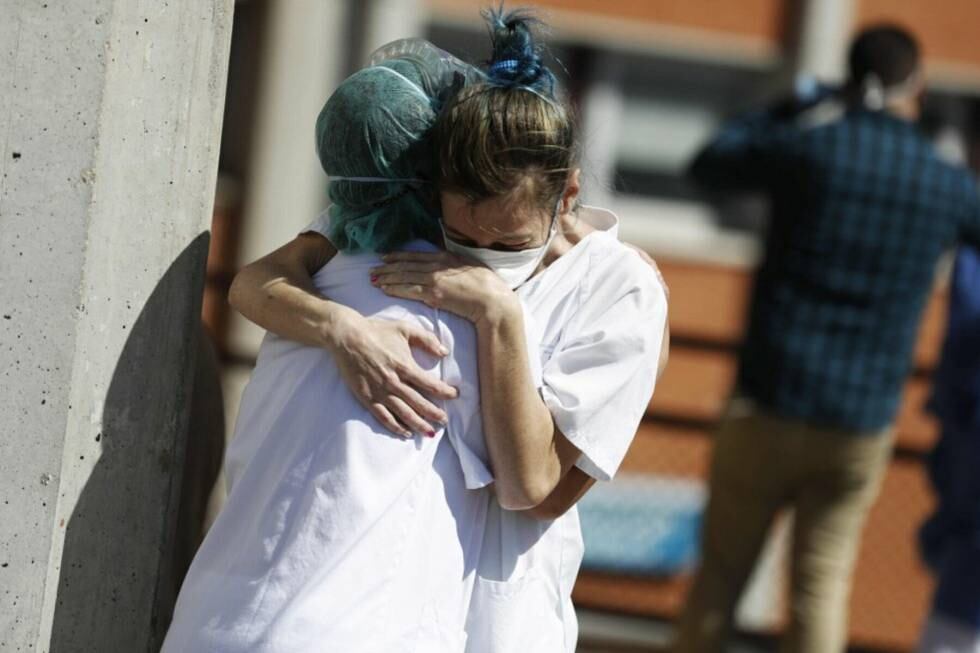 Two health workers hug outside the Severo Ochoa hospital in Madrid.