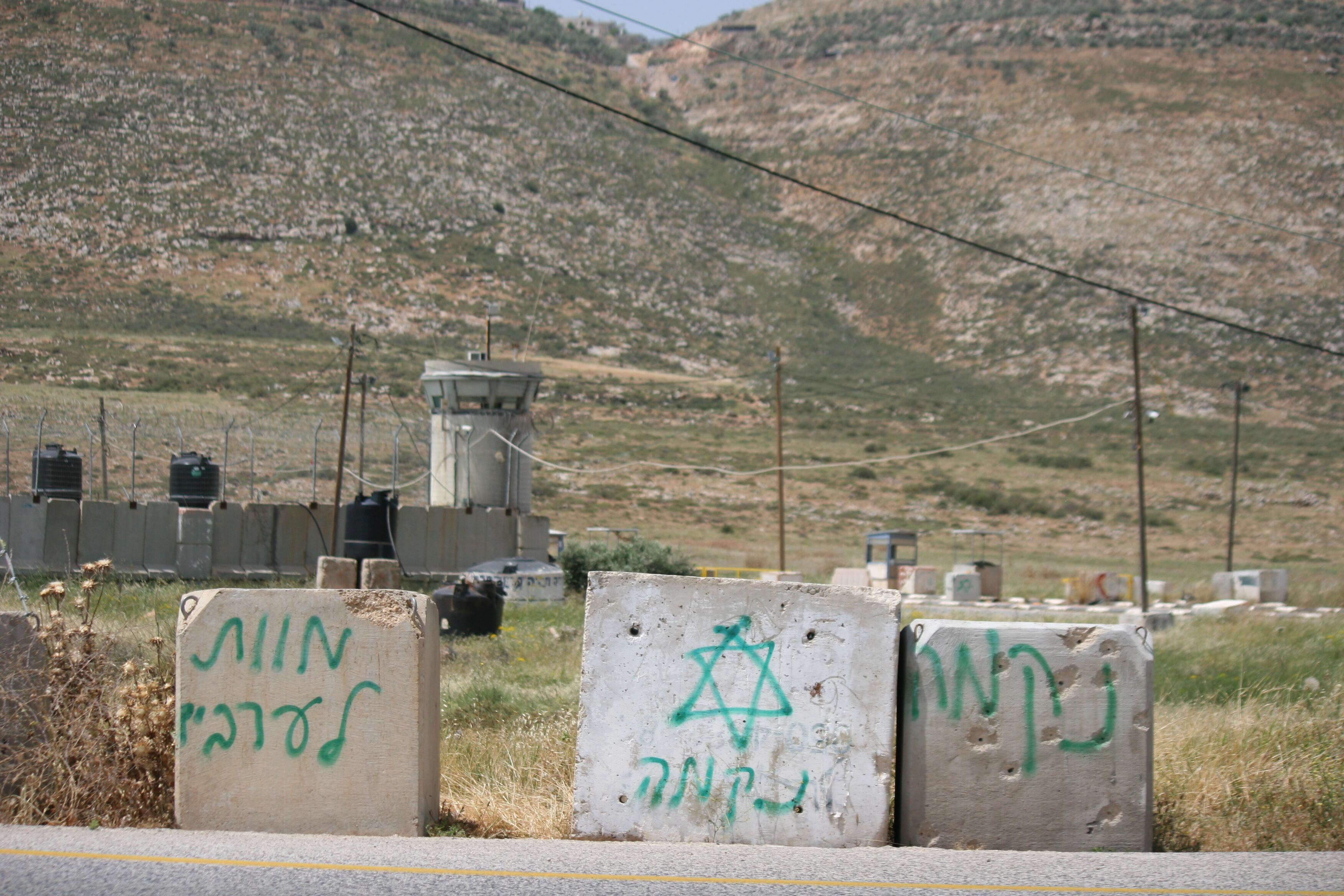 Barriers next to a military base painted with the phrases 