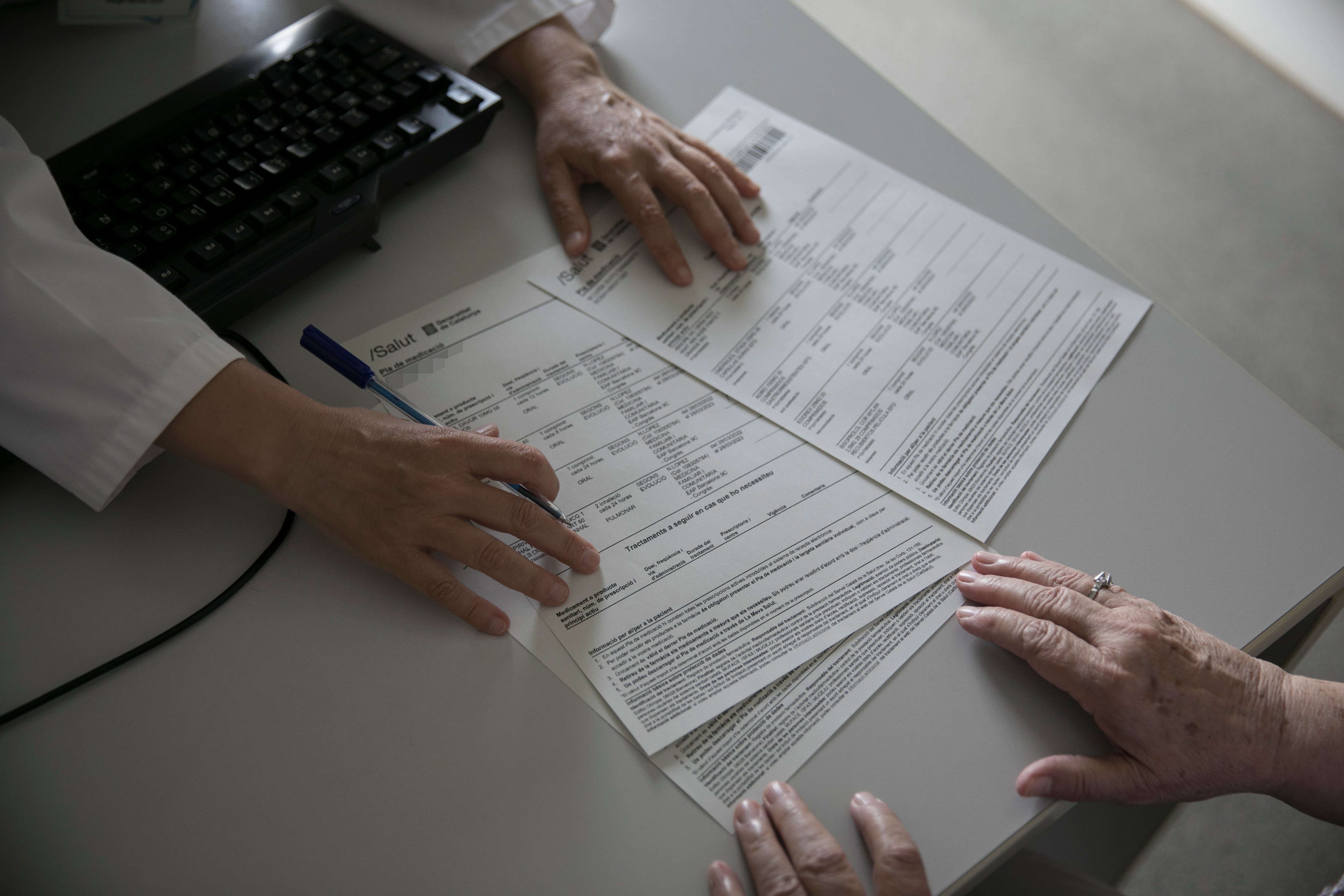 A family doctor reviews a patient’s medications with her at a health center in Barcelona.