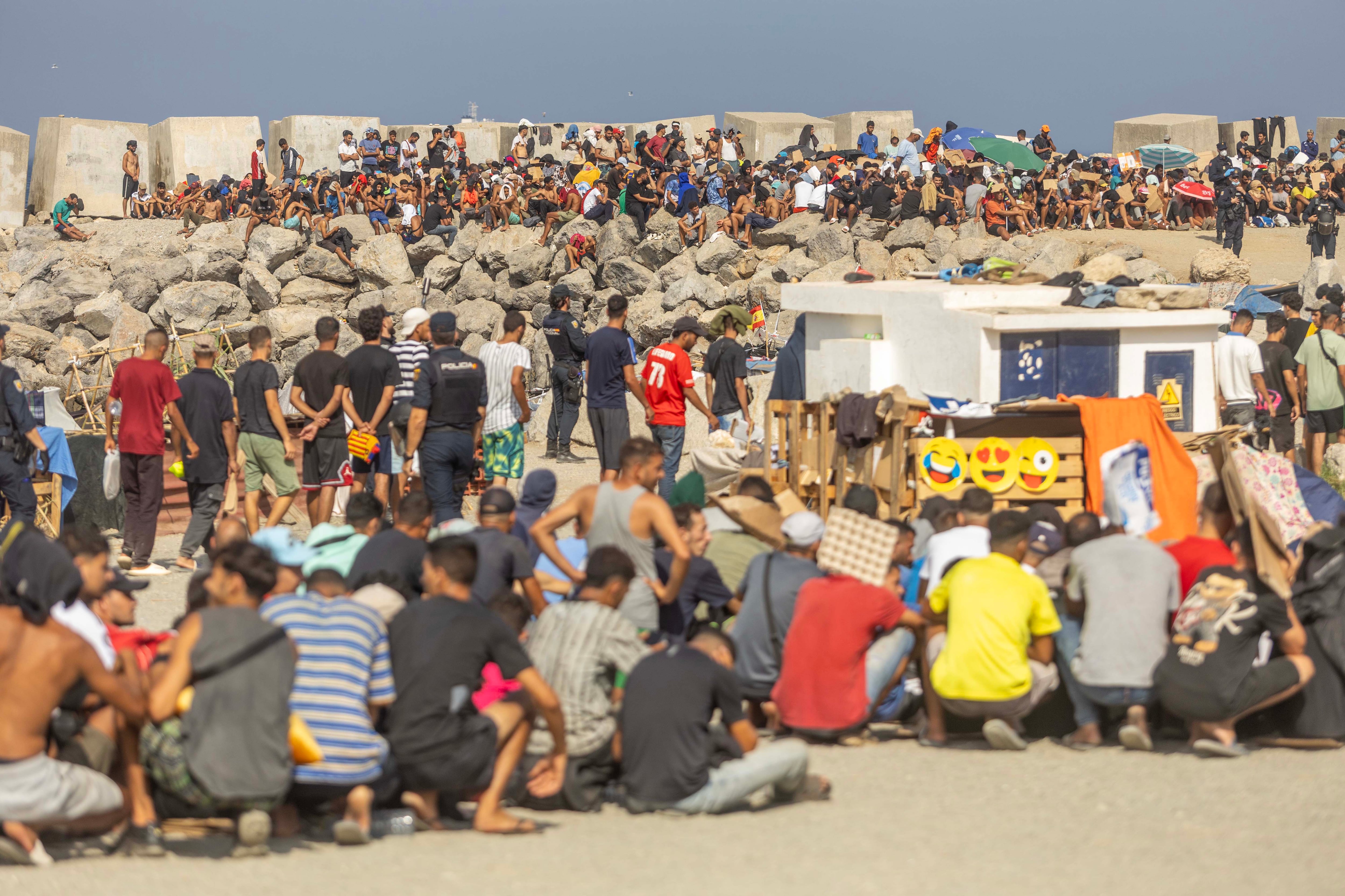 Immigrants wait for the distribution of food at Trampolín beach in Ceuta on September 3.
