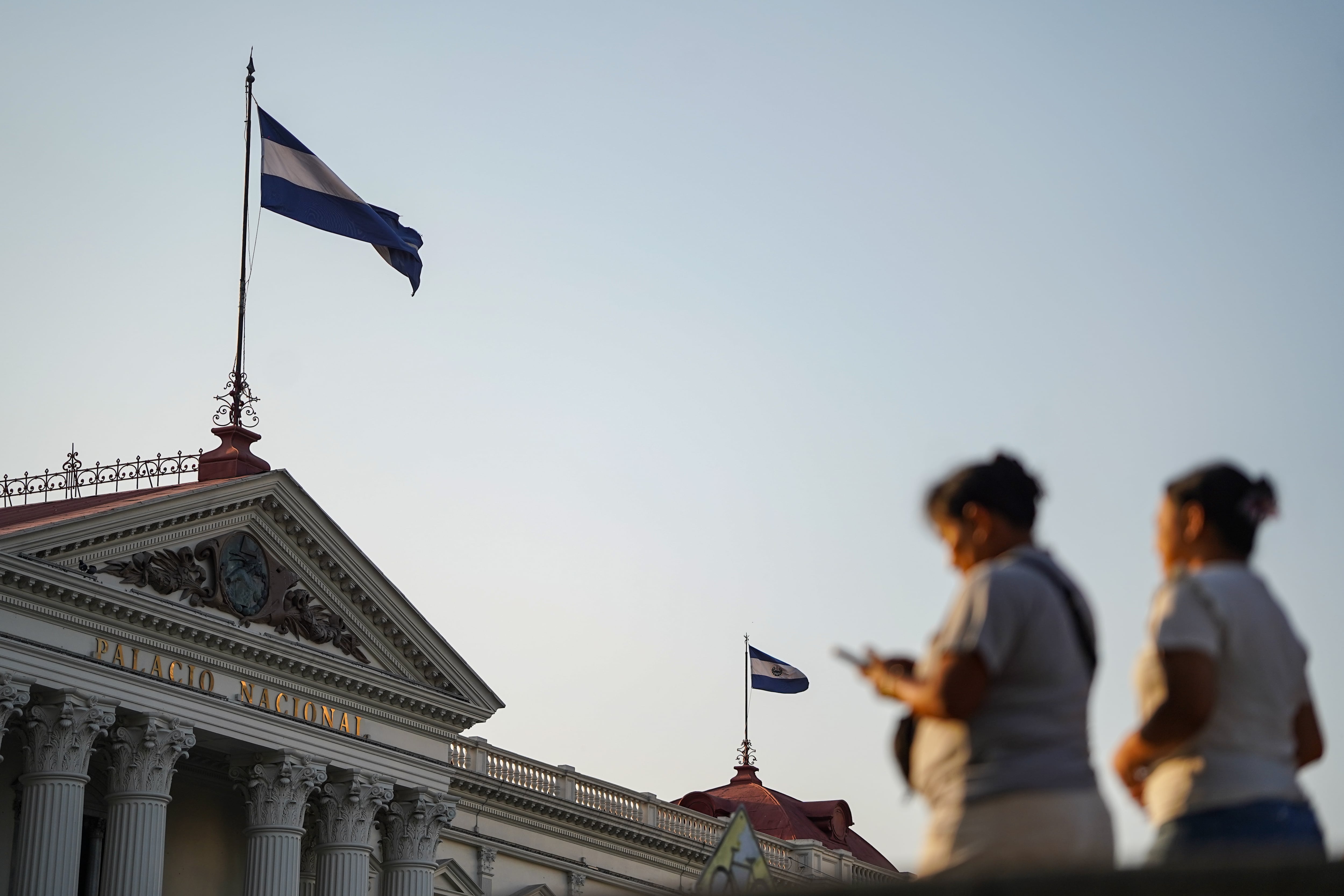 Women walk in front of the National Palace in San Salvador on April 16.