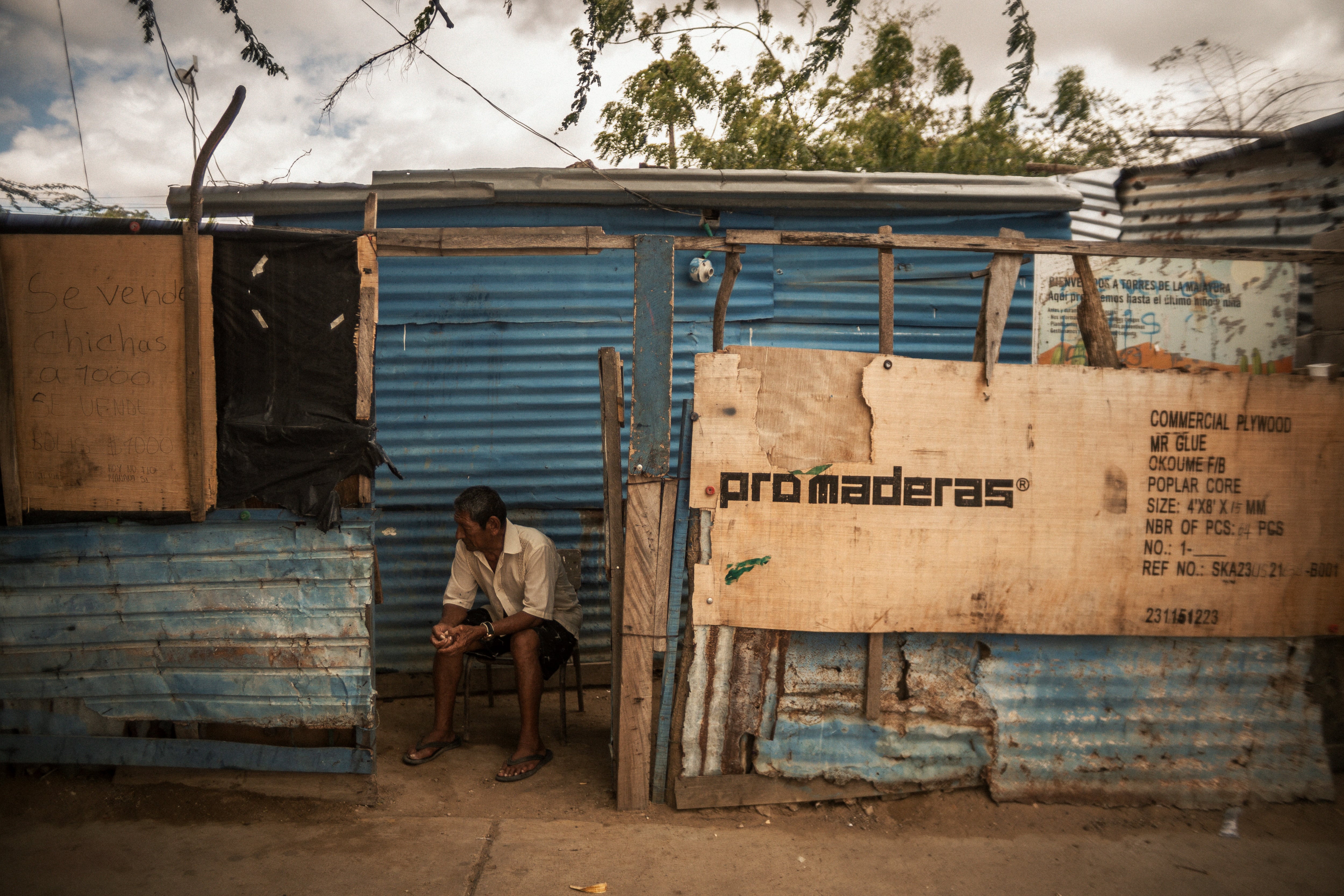 A man sits outside his home in La Pista, La Guajira, Colombia, on April 24, 2025.