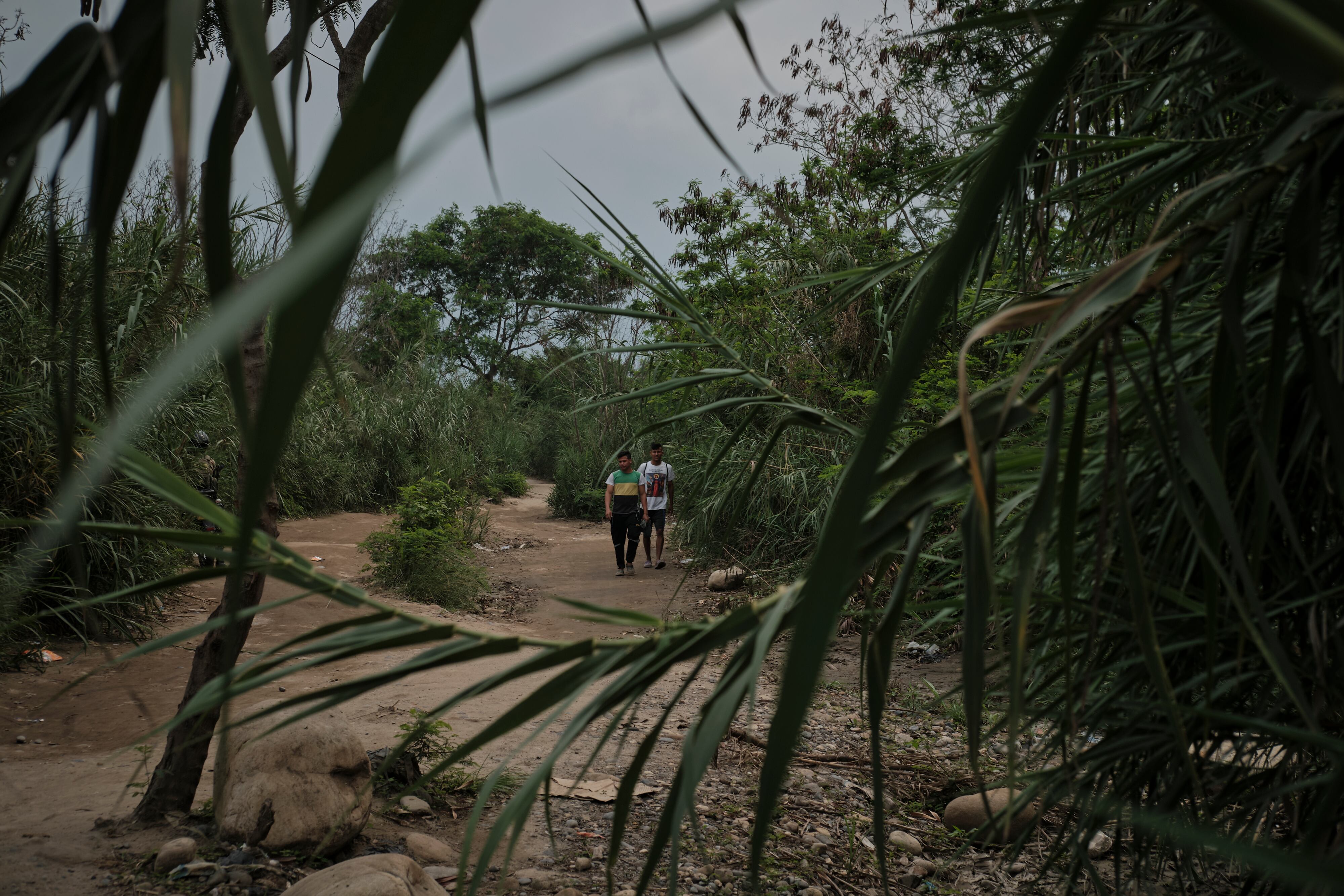 Two young men cross the La Platanera trail on the border between Colombia and Venezuela.