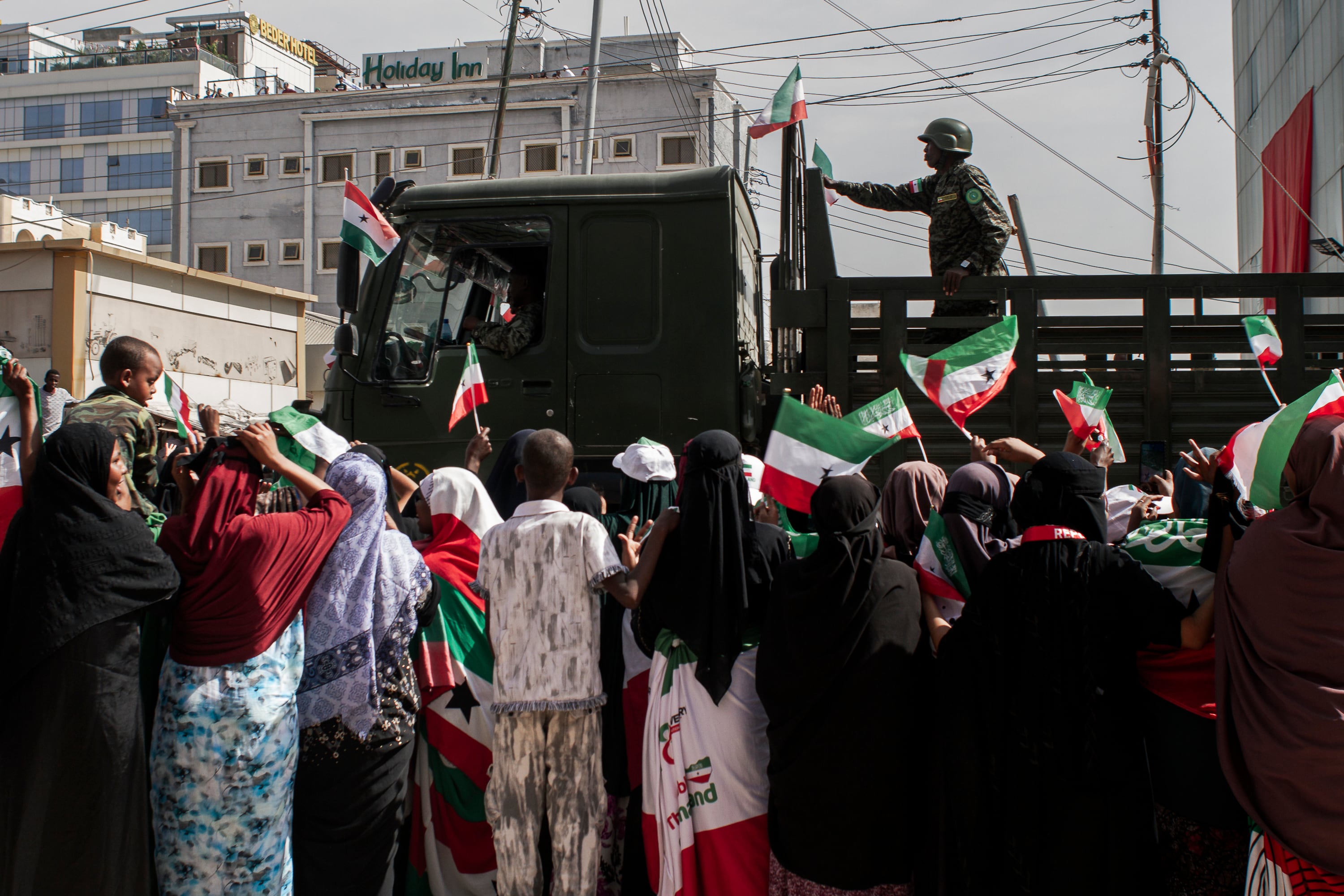 Citizens of Hargeisa wave Somaliland flags as a military truck passes by, during the May 18 parade. 
