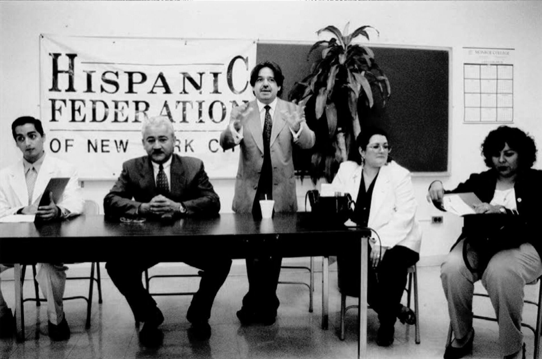 Luis A. Miranda Jr. speaks at a 1993 Hispanic Federation press conference with then member Roberto Ramirez (seated center) and Frankie Miranda, Lorraine Cortes-Vazquez and Lillian Rodriguez Lopez, who would later become Federation presidents.