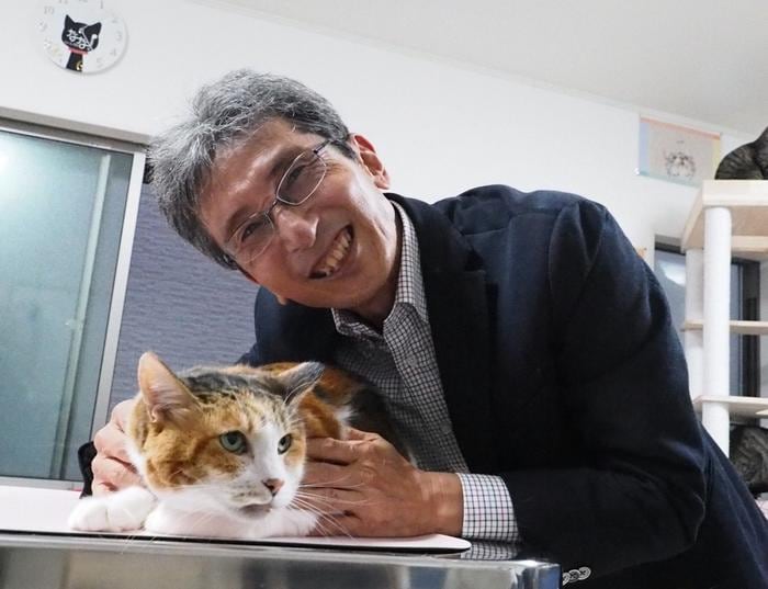 Hiroyuki Sasaki, a geneticist with a soft spot for felines, with one of the calico cats at a shelter.