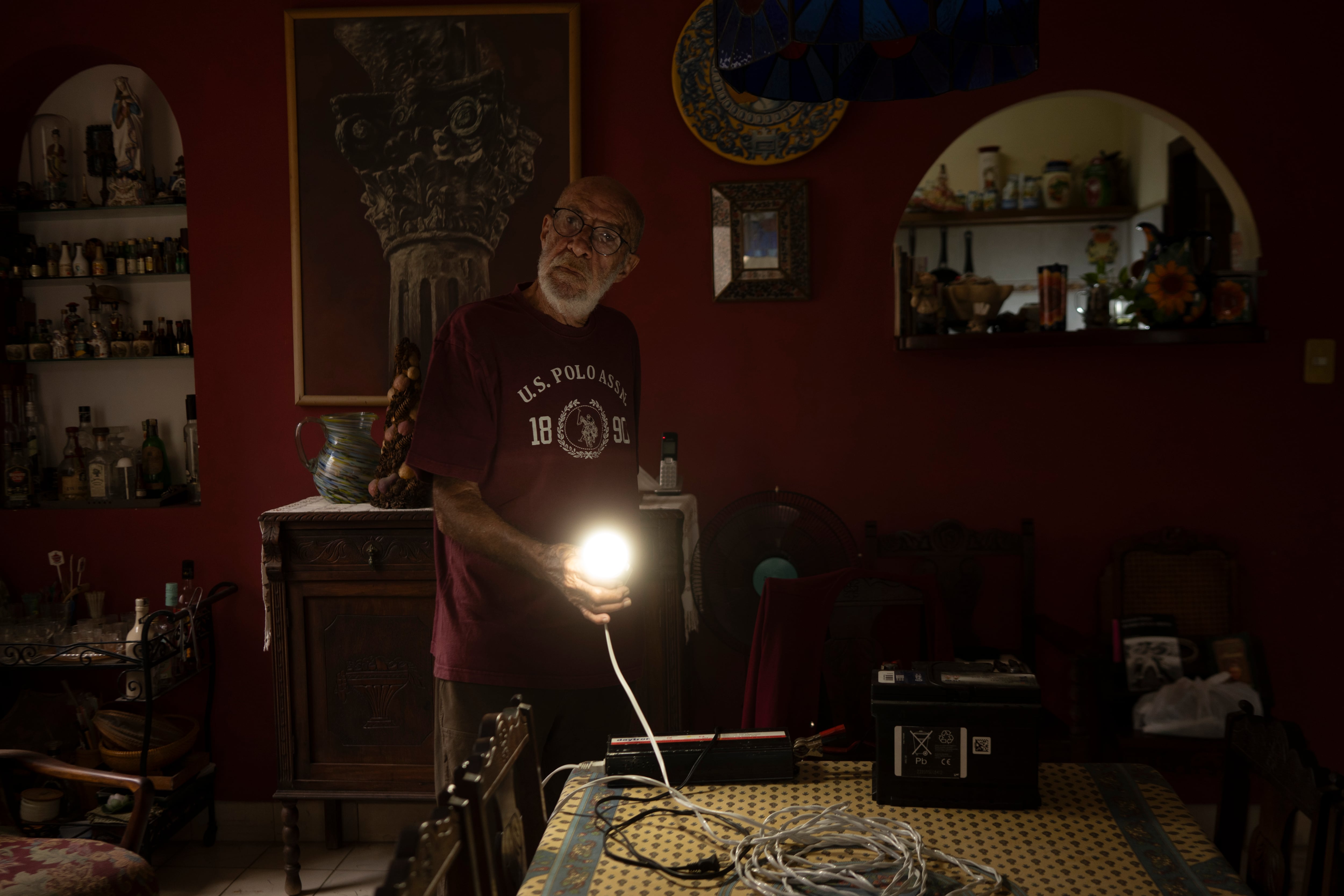 Aurelio shows how he receives electricity from a car battery during a blackout in Havana, on March 18.